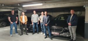 Illustration photoréaliste montrant des chauffeurs VIP en formation dans le parking de France Limousine Service, entourés de limousines, vans et minibus de luxe. Les chauffeurs, en tenue civile, ont suivi un exercice de conduite sécurisée. Ambiance professionnelle et luxueuse, éclairage naturel, style moderne et détaillé. (Tous Droits réservés SF3Pro)